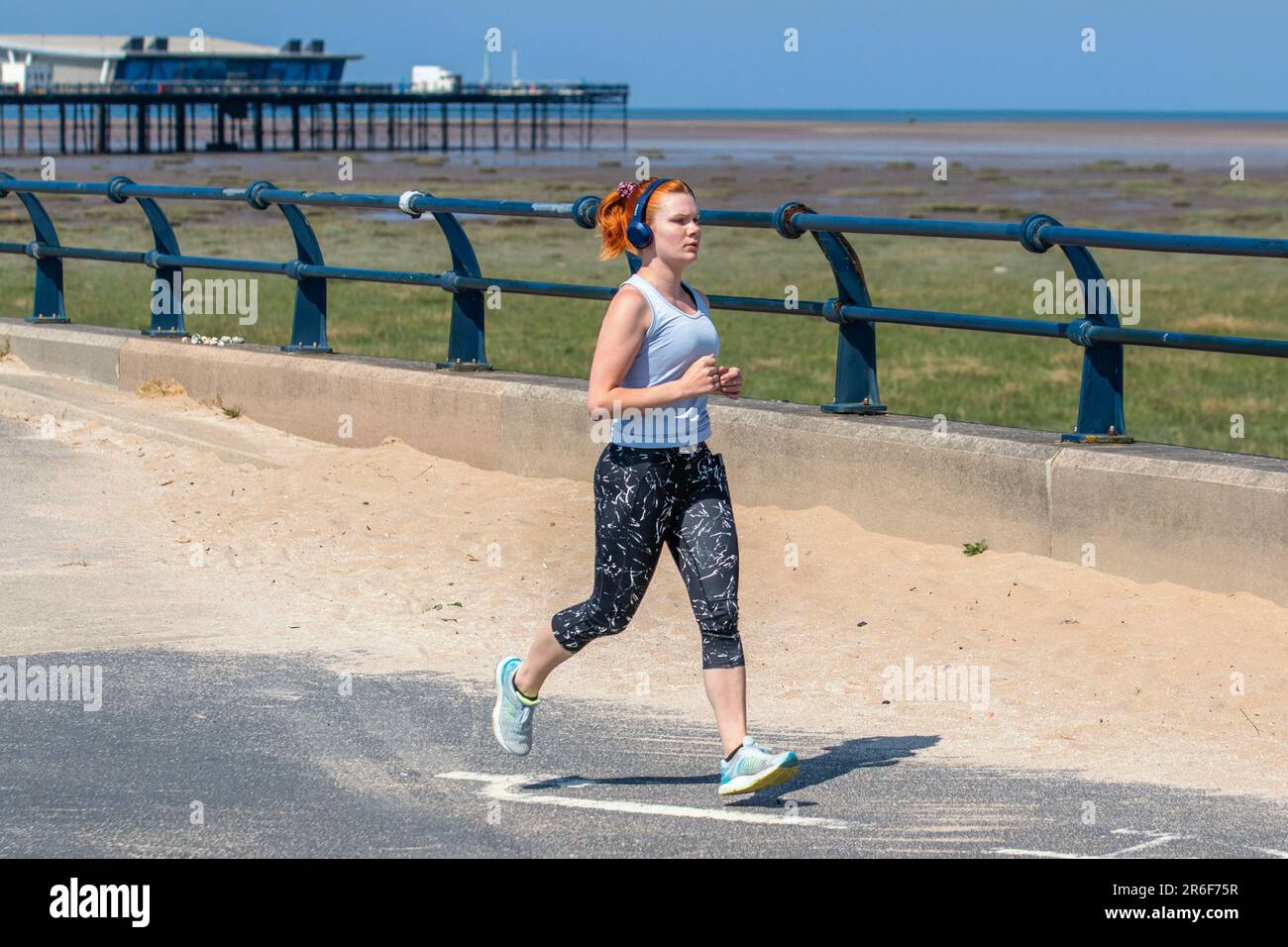 Jogger in Southport, Merseyside. Wetter in Großbritannien. 9. Juni 2023 heißer, sonniger Tag, an dem die Anwohner und Urlauber leichte Übungen an der Strandpromenade machen. Quelle: MediaWorldImages/AlamyLiveNews Stockfoto