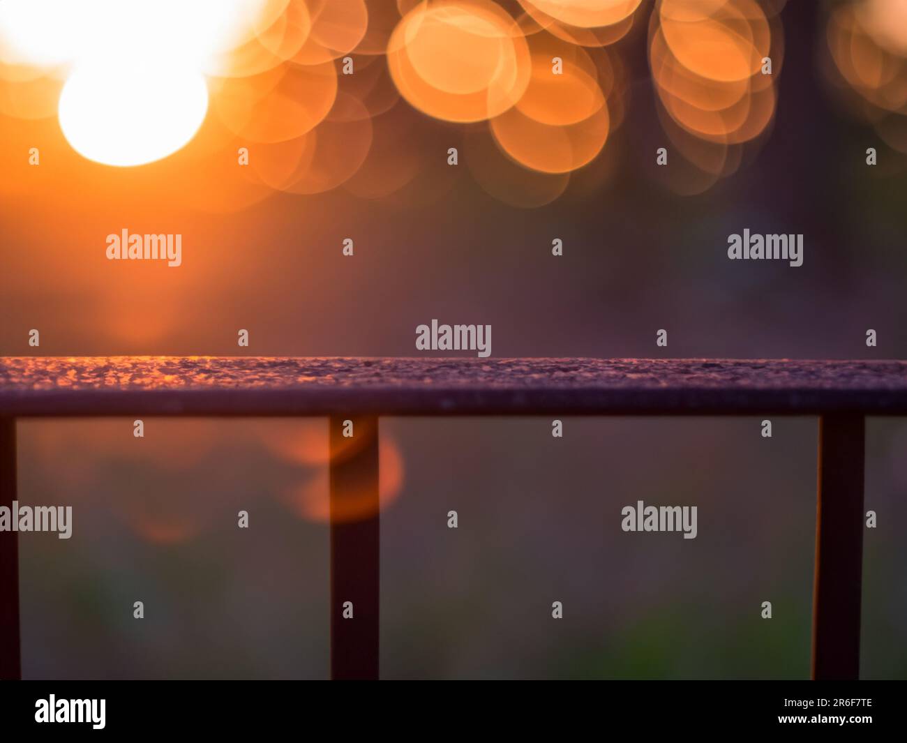 Ein verschwommenes Foto des Sonnenuntergangs hinter einem Zaun. . Stockfoto