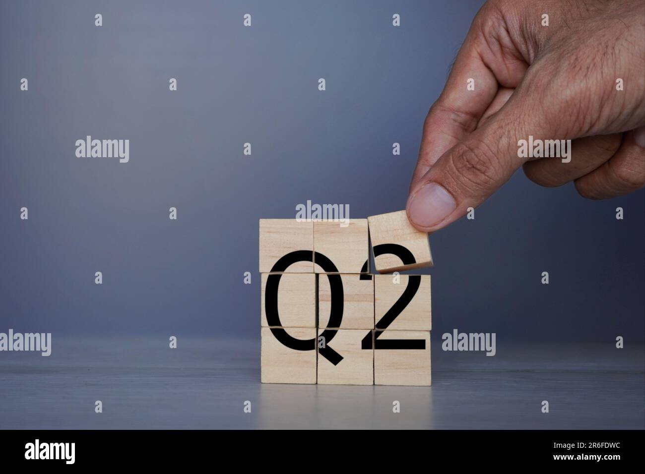 Von Hand platzierter Holzwürfel mit Text Q2. Geschäftskonzept für das zweite Quartal Stockfoto