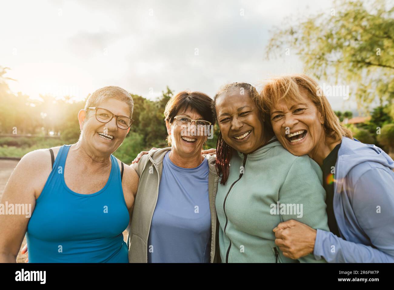 Fröhliche multirassische weibliche Freunde, die nach dem Training im Park vor der Kamera lächeln Stockfoto