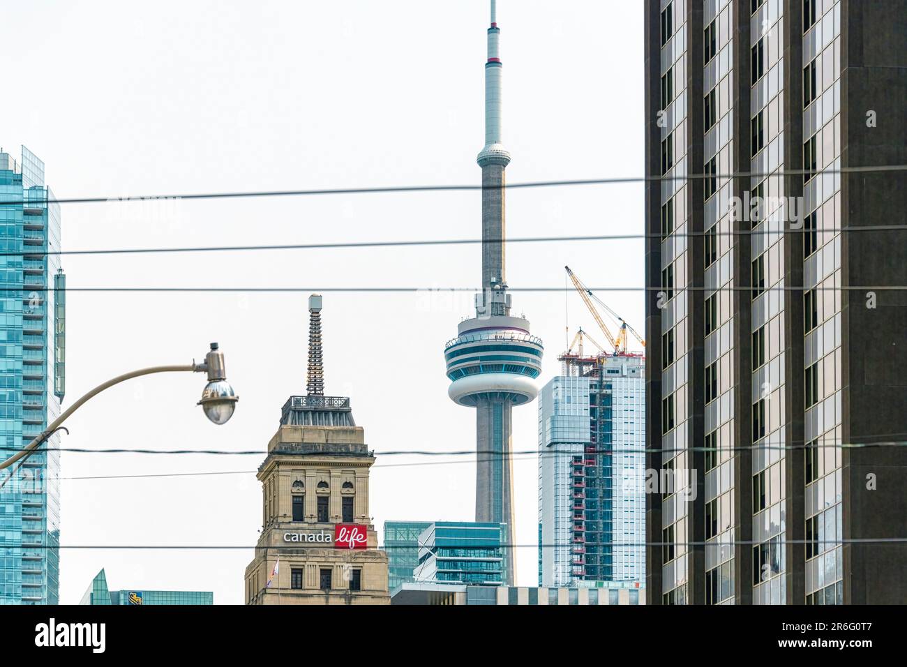 Toronto, Kanada - 4. Juni 2023: Das Canada Life Building und der CN Tower. Andere Gebäude der Stadt sind in der Szene. Stockfoto