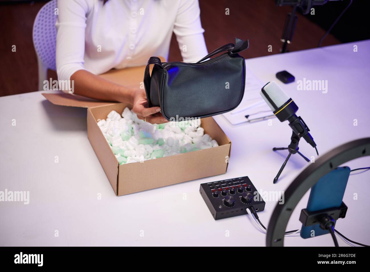 Nahaufnahme eines Modebloggers, der eine Kunstledertasche auspackt und ein Video filmt Stockfoto