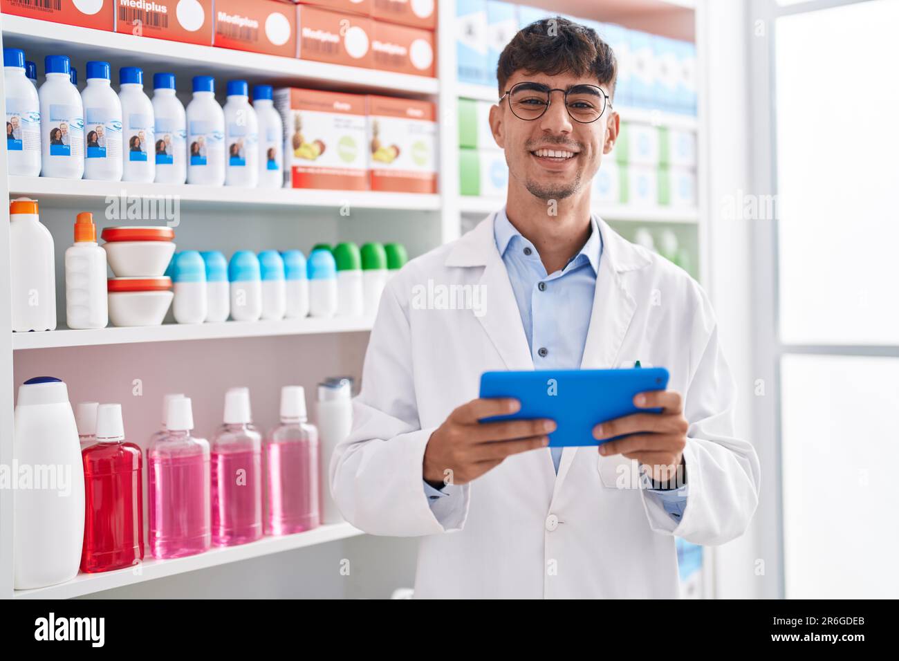 Junger hispanic-Mann Apotheker mit Touchpad in der Apotheke arbeiten Stockfoto