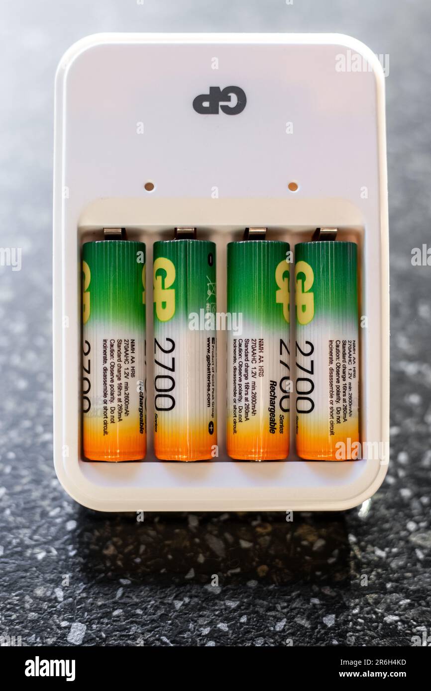 Vier Akkus in einem weißen Ladegerät. Gerätebatterien für Blitzgeräte. Russland, Anapa-10.05.2023 Stockfoto