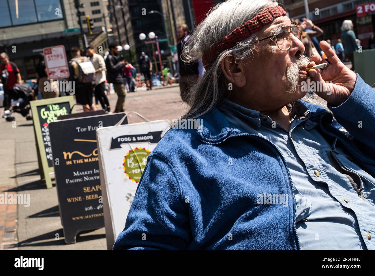 Seattle, USA. Juni 2023. Eine stilvolle Person, die in der Sonne auf dem berühmten Pike Place Market sitzt. Stockfoto