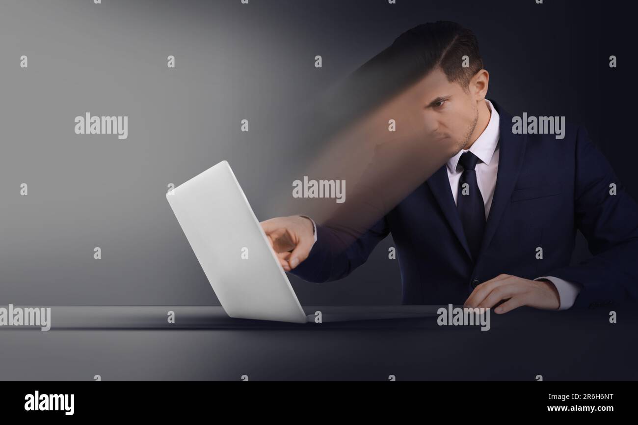 Gedankenkontrolle, Gehirnwäsche oder Zwangskonzepte bei der Arbeit. Ein Mann, der sich am Tisch in einem Laptop auflöst Stockfoto