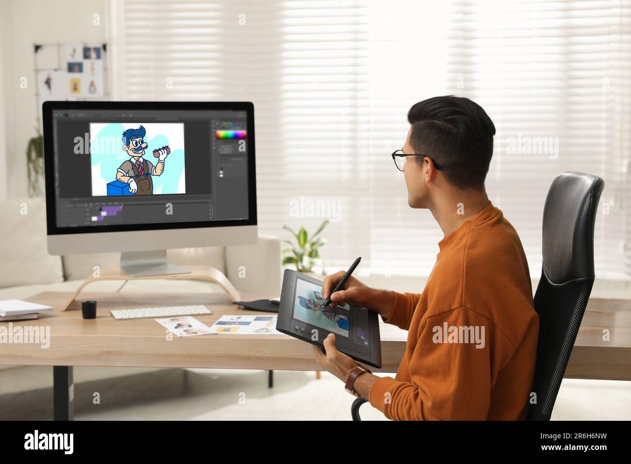 Animator mit Grafiktablett und Computer. Abbildung auf Bildschirmen Stockfoto