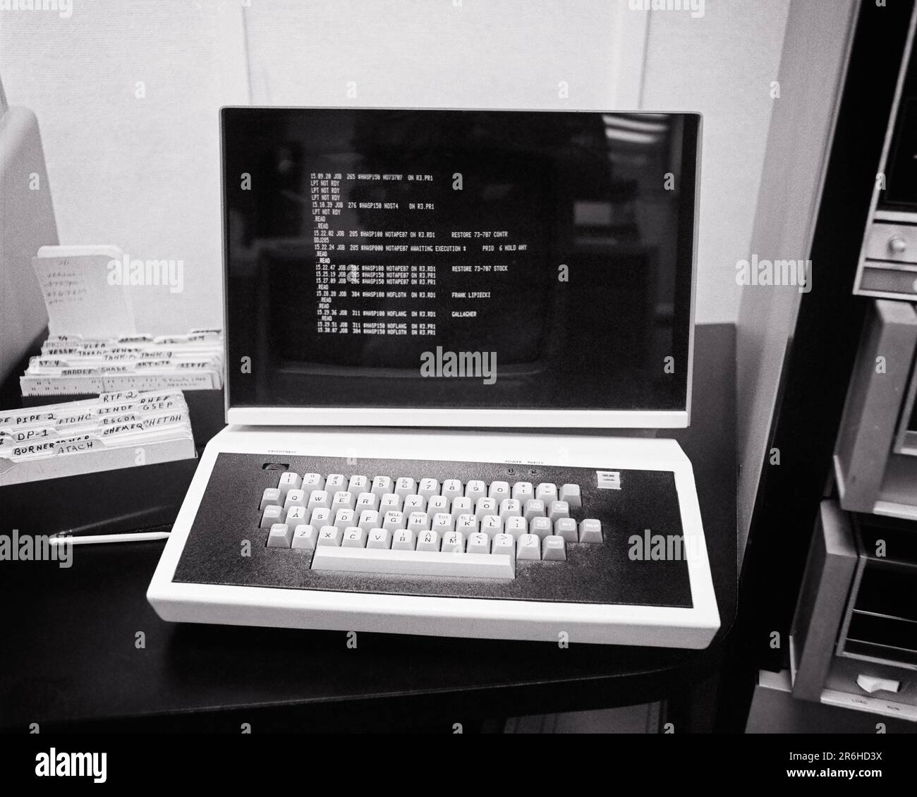 1970S EIN FRÜHER, STUMPFES KATHODENSTRAHLRÖHREN-CRT-MONITOR UND EINE TASTATUR, DIE ENTWEDER MIT EINEM GROSSEN GROSSRECHNER ODER EINEM MINI-BÜRO-COMPUTERSYSTEM VERBUNDEN SIND - O4231 HAR001 HARS OLD FASHIONED Stockfoto