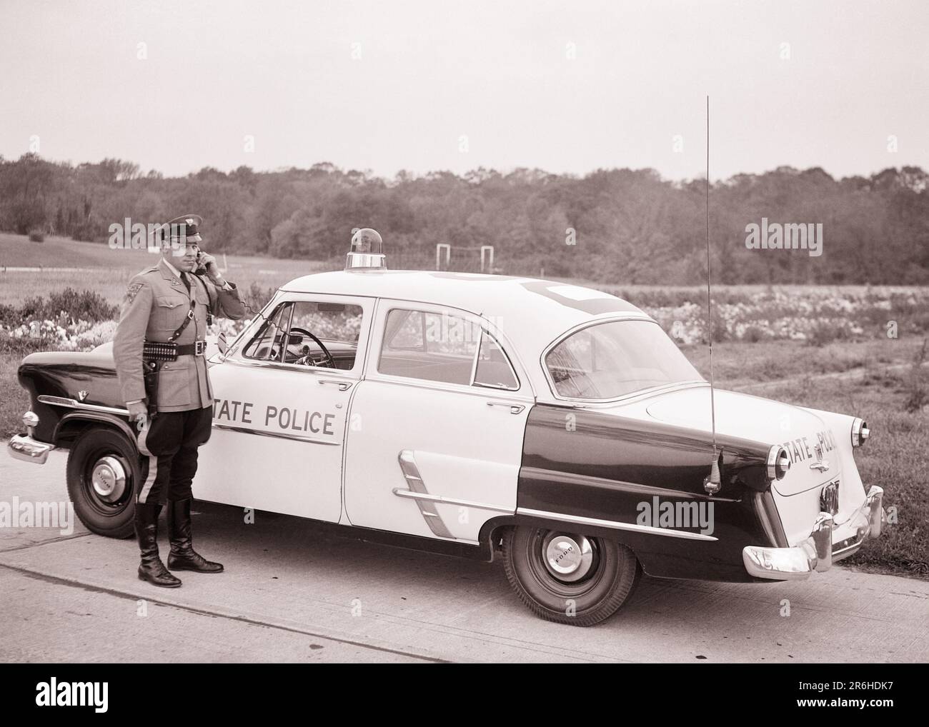 1950S NJ STATE POLICE PATROUILLENWAGEN TROOPER ÜBER HANDY MIT DEM HAUPTQUARTIER REDEN ANDERE AUTOS ODER FLUGZEUG NEW JERSEY USA - Q54353 CPC001 HARS KARRIERE DIENEN FAHRZEUGSICHERHEITSTECHNOLOGIE SICHERHEITSINFORMATIONEN FORD LIFESTYLE OVERHEAD JOBS KOMMUNIZIEREN KOPIERRAUM VOLLE LÄNGE HIGHWAY PERSONS INSPIRATION AUTO MÄNNCHEN ORDER OFFICER BERUF VERTRAUEN TRANSPORT B&W COP QUALIFIKATION BERUF SCHÜTZEN FÄHIGKEITEN HOCHWINKEL ABENTEUER UND AUTOS KARRIERE EXTERNE FÜHRUNGSEBENE FORTSCHRITT STOLZ GELEGENHEIT AUTORITÄT BERUFE TELEFONE UNIFORMEN VERWENDEN CONNECTION PATROL KONZEPTIONELLE TELEFONE AUTOS Stockfoto