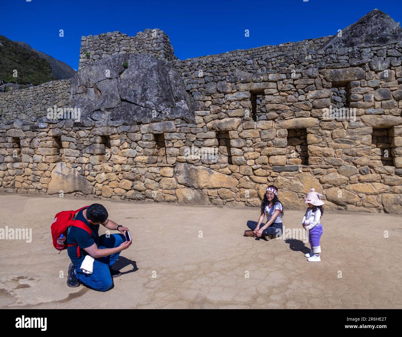 Familienvater, der Ehefrau und Tochter fotografiert, Inka-Ruinen von Machu Picchu, Peru, Südamerika Stockfoto