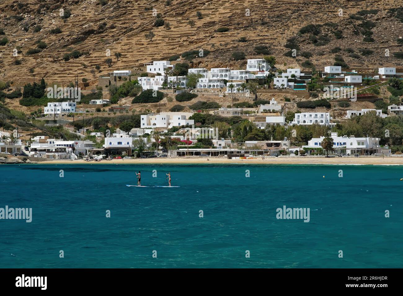 IOS, Griechenland - 16. Mai 2021 : Junge Touristen, die Stehpaddeln am berühmten Strand von Mylopotas iOS Greece genießen Stockfoto
