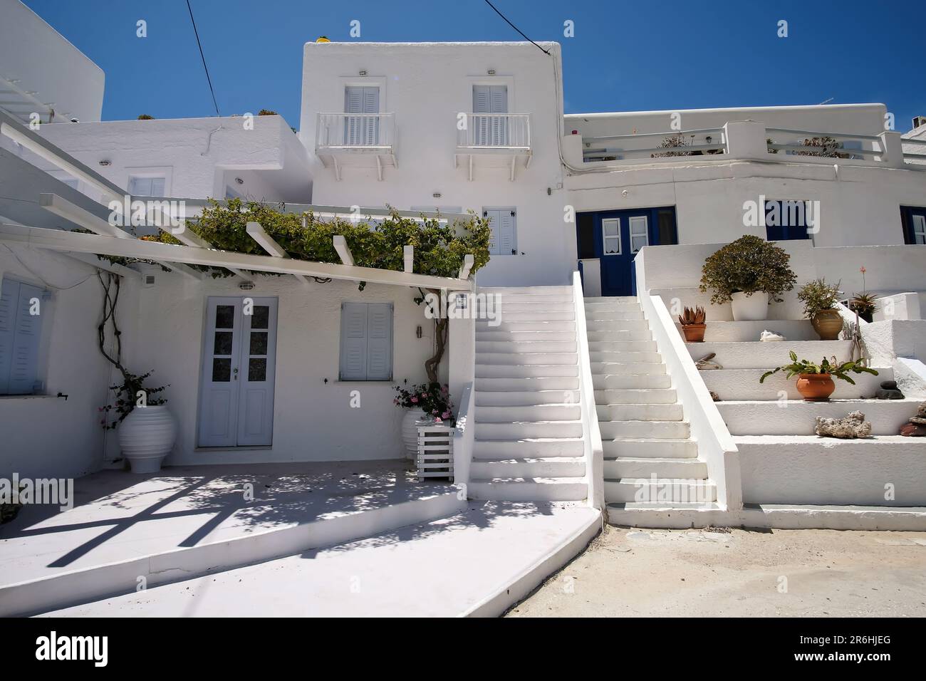 IOS, Griechenland - 16. Mai 2021 : Ein weiß getünchtes Hotel, das Zimmer mit der typischen kykladischen Architektur vor dem Mylopotas iOS Greece mietet Stockfoto