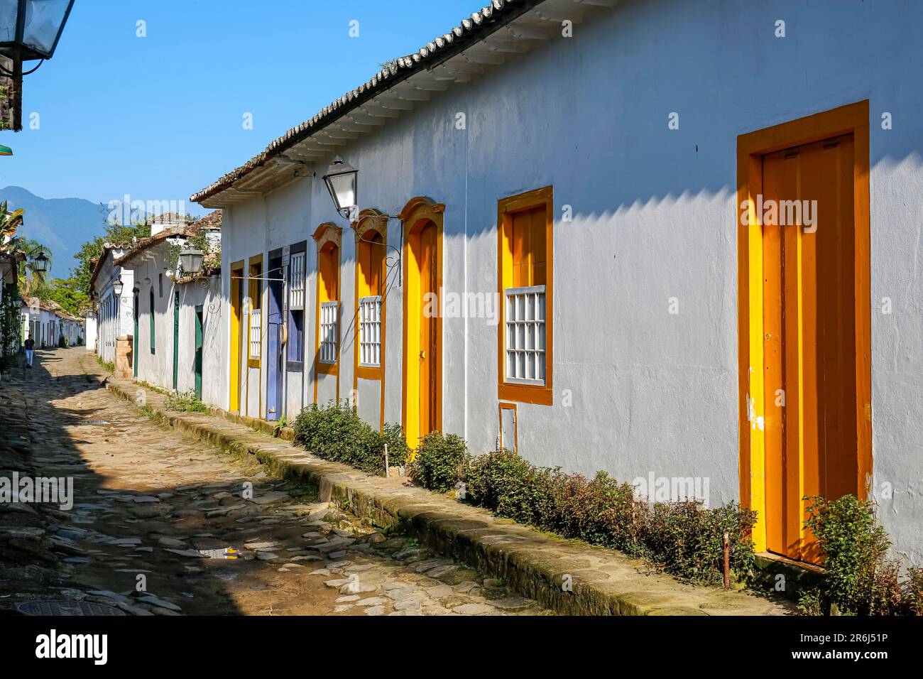 Typische kopfsteingepflasterte Straße mit bunten kolonialen Gebäuden in der späten Nachmittagssonne in der historischen Stadt Paraty, Brasilien Stockfoto