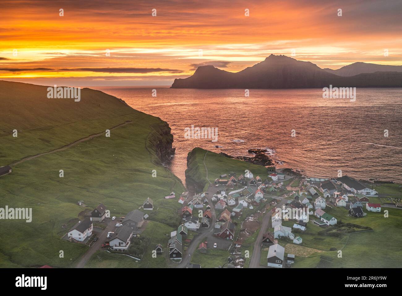 Feuriger Himmel bei Sonnenaufgang über der Insel Kalsoy und dem Dorf Gjogv, Blick von oben, Eysturoy Island, Färöer Inseln, Dänemark, Europa Stockfoto