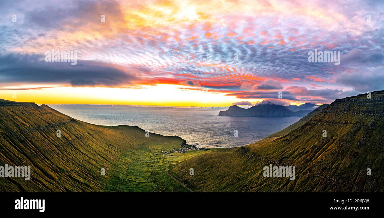 Dramatischer Himmel mit Wolken bei Sonnenaufgang über dem Küstendorf Gjogv, Luftaufnahme, Eysturoy Island, Färöer Inseln, Dänemark, Europa Stockfoto