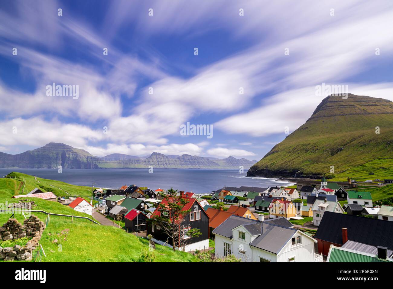 Flauschige Wolken am Sommerhimmel über den traditionellen Häusern von Gjogv, Eysturoy Island, Färöer Inseln, Dänemark, Europa Stockfoto