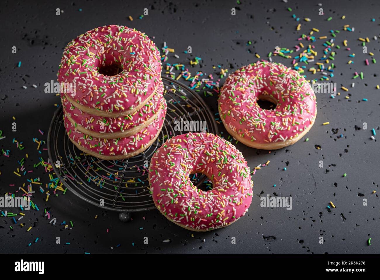 Frische und leckere rosa Donuts als Nachtisch zum Mitnehmen. Donuts ist das beliebteste Dessert. Stockfoto