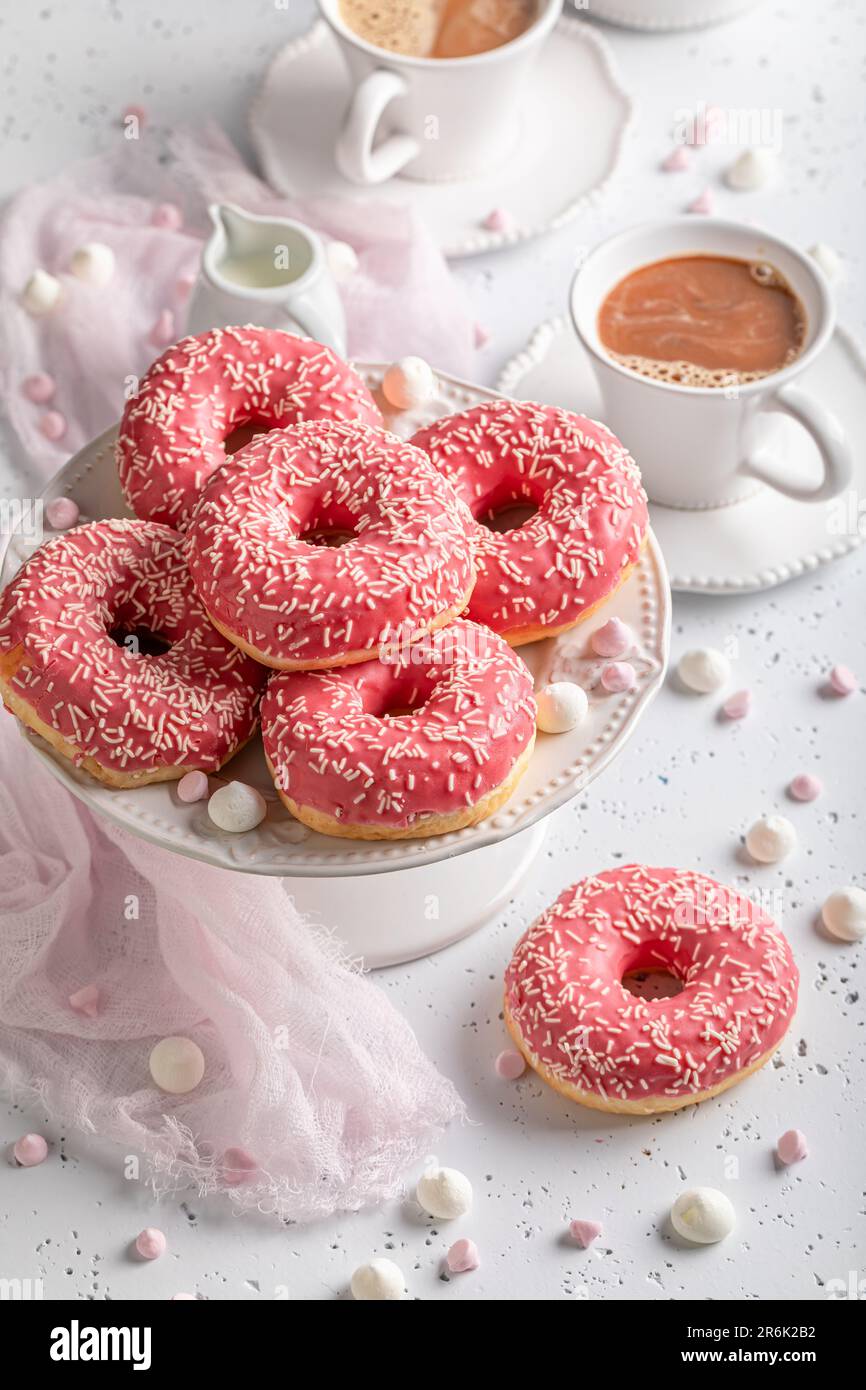 Frische und beliebte rosa Donuts und Kaffee als beste Nachspeise