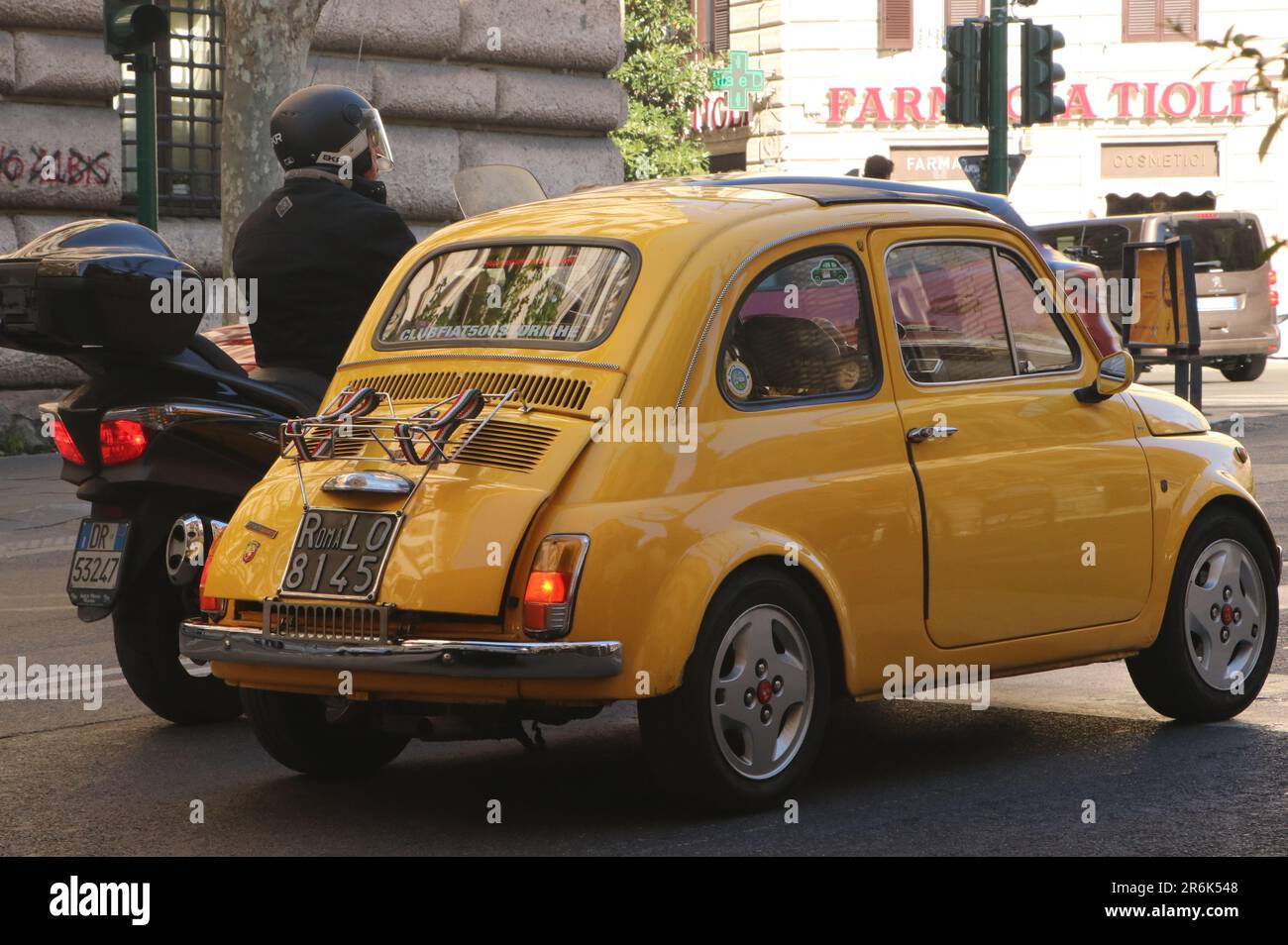 Gelber klassischer Fiat 500 neben dem Motorrad auf der Straße in Rom, Italien, April 22 2023 Stockfoto