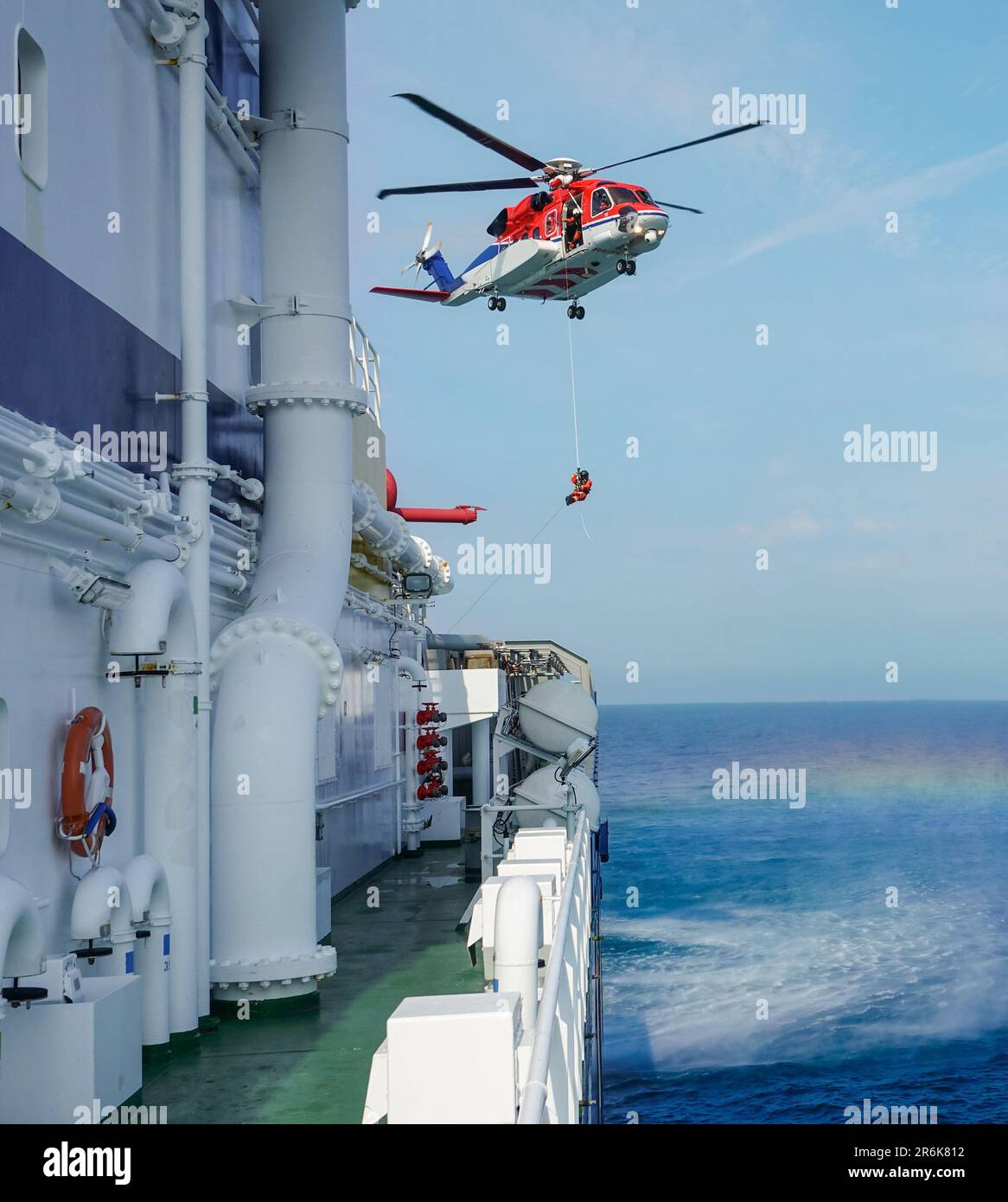 Luft-See-Rettungseinsätze. Roter Rettungshubschrauber und Öltankschiff. Brigade und Rettungsteam. Die Küstenwache. Der Unfall auf dem Wasser. Schiff ha Stockfoto