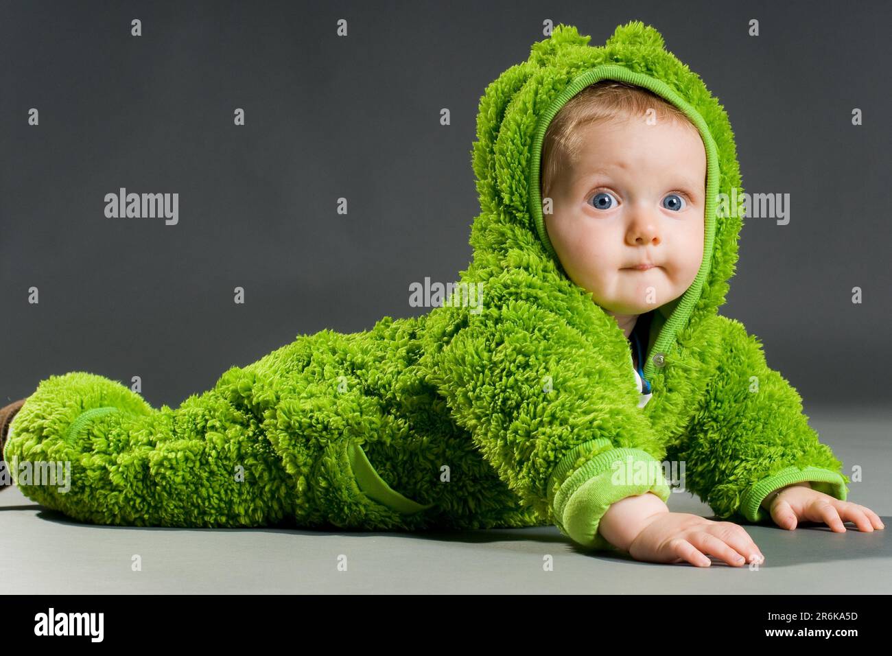 Ein süßes Baby in einem pelzigen Froschkostüm Stockfoto