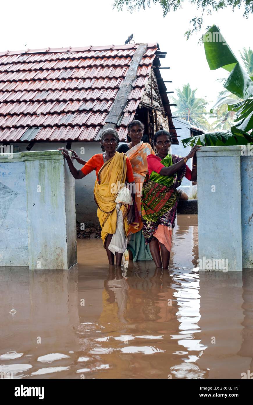 Frauen, die vor ihrem Haus standen und von Regenwasser überflutet wurden, Tamil Nadu, Südindien, Indien, Asien Stockfoto