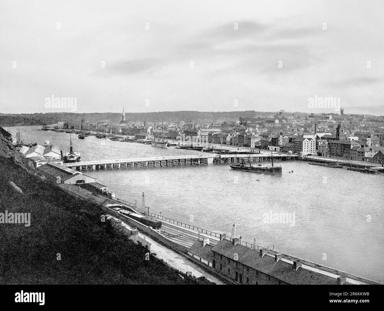 Ein Blick aus dem späten 19. Jahrhundert auf den Fluss Suir, der unter der Holz- und Eisenbrücke fließt und später durch die Reisbrücke in den frühen 1980er Jahren ersetzt wurde. Waterford City im Südosten Irlands ist die älteste Stadt in der Republik Irland. Waterford Port war über ein Jahrtausend lang ein wichtiger Hafen und während des 19. Jahrhunderts der Standort der Neptun Werft, als die Familie Malcomson die größte Flotte von Eisendampfern der Welt zwischen Mitte der 1850er und Ende der 1860er Jahre baute und betreibt. Stockfoto
