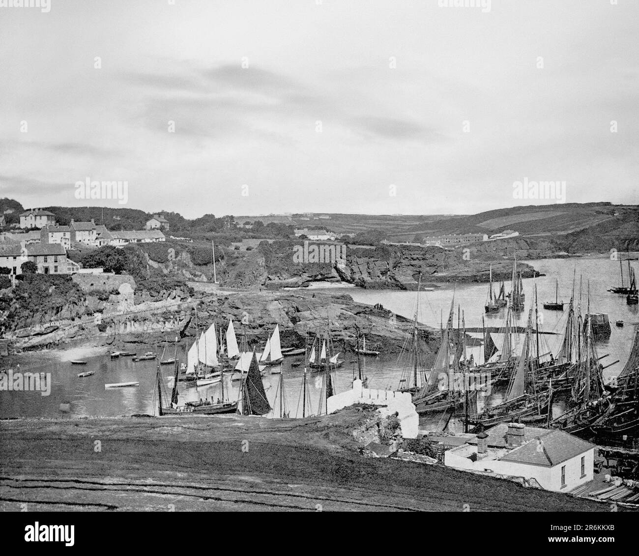 Ein Blick aus dem späten 19. Jahrhundert auf viele Fischerboote (oder Smacks) in Dunmore East, einem beliebten Touristen- und Fischerdorf auf der Westseite des Waterford Harbour an Irlands Südostküste. Stockfoto