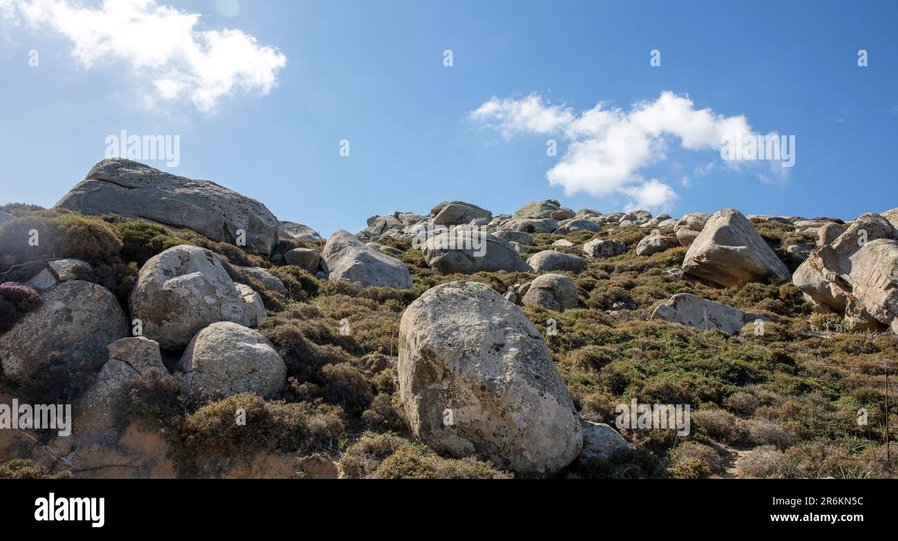 Riesiger, glatter vulkanischer Granitfelsen, der das Volax Dorf auf Tinos Insel Kykladen Griechenland umgibt. Sommer, sonniger Tag, blauer Himmelshintergrund. Stockfoto