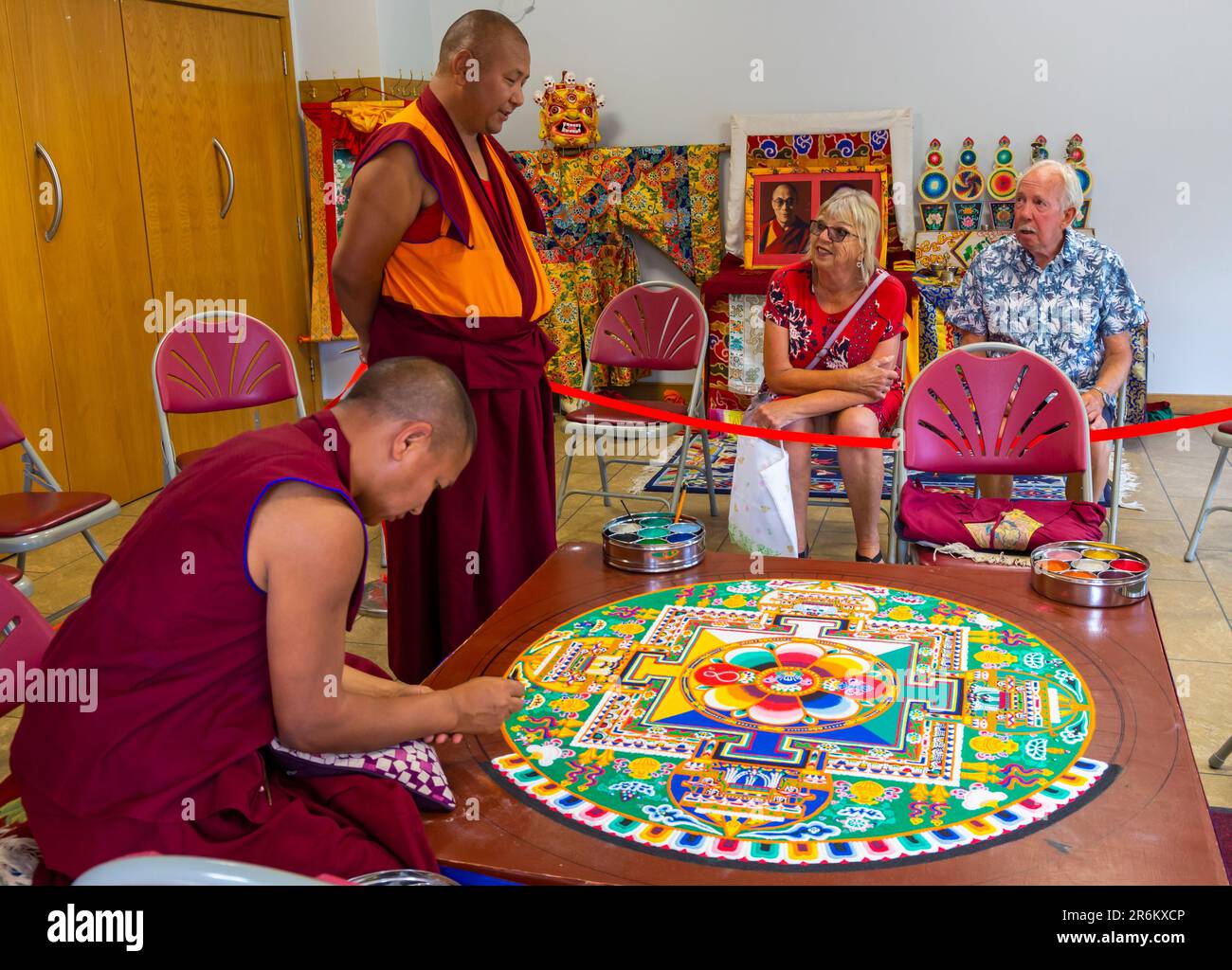 Wimborne, Dorset, Großbritannien. 10. Juni 2023 Die tibetischen buddhistischen Tashi-Lhunpo-Mönche erschaffen ein Sandmandala, das Mandala des Amitabha-Buddha, was „grenzenloses und unendliches Leben“ bedeutet, beim Wimborne Folk Festival. Die Sandmandala besteht aus Millionen von farbigen Sandkörnern, die mühsam mit hohlen Metalltrichtern in ein aufwändiges Design gelegt wurden. Danach wird er zerlegt, der Sand nach oben geschwemmt und wieder zur Erde oder zu fließendem Wasser als mächtiges Symbol der vorübergehenden Natur des Lebens angeboten. Kredit: Carolyn Jenkins/Alamy Live News Stockfoto