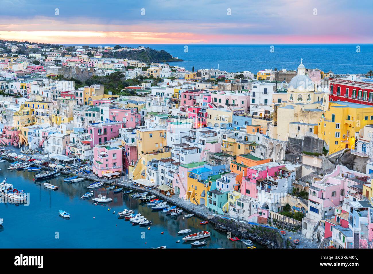 Erhöhte Aussicht auf das farbenfrohe italienische Fischerdorf Marina Corricella in der Dämmerung, die Insel Procida und das Tyrrhenische Meer Stockfoto