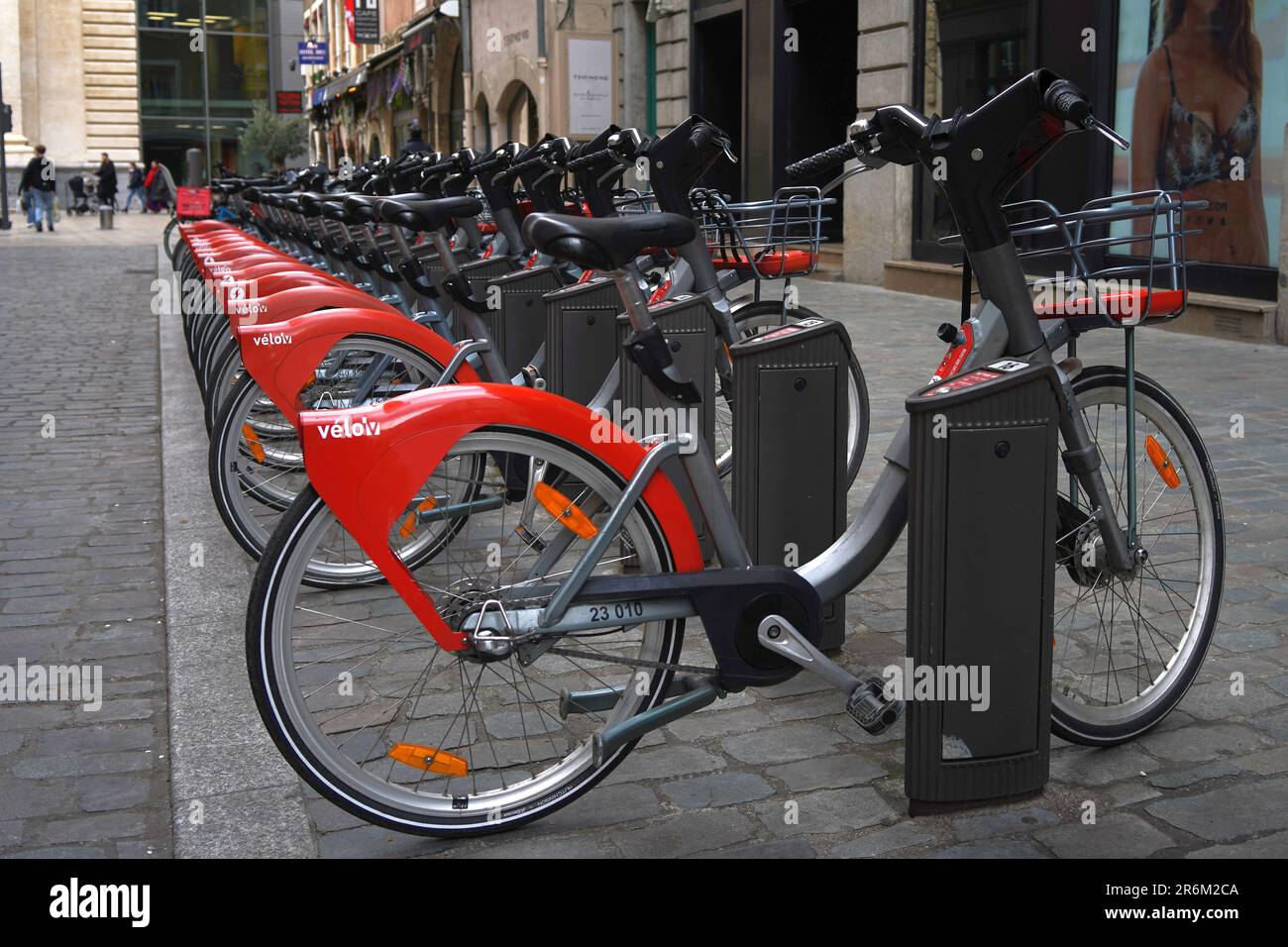 Rote öffentliche Fahrräder können nacheinander in Lyon, Frankreich, gemietet werden Stockfoto