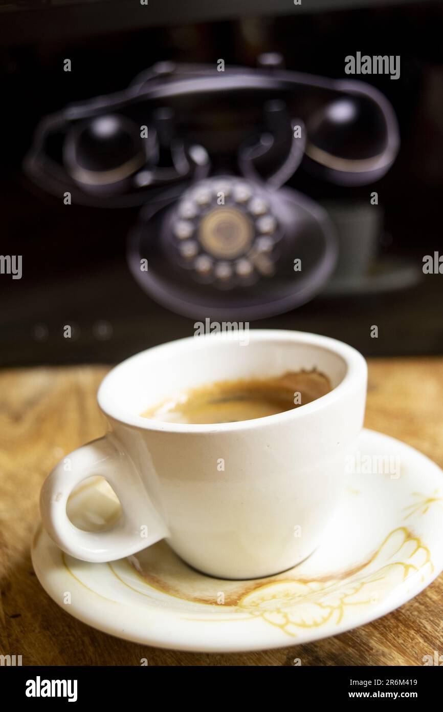 Espresso-Kaffee vor einem alten analogen Telefon Stockfoto