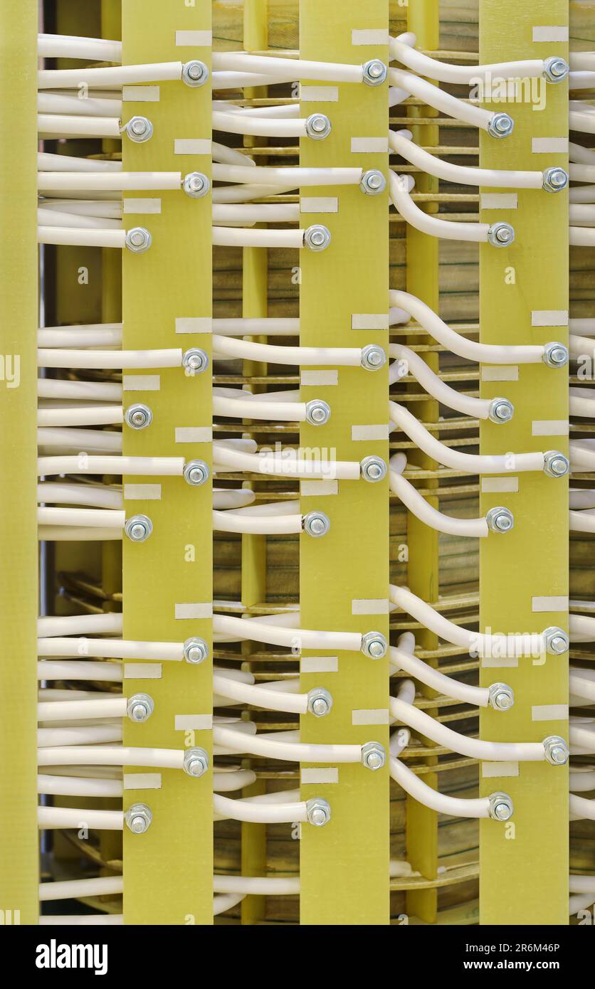 Elektrische Installation, weiße isolierte Drähte auf grünem Verbundglas, vertikale Nahaufnahme von vorne, abstrakter industrieller Hintergrund Stockfoto