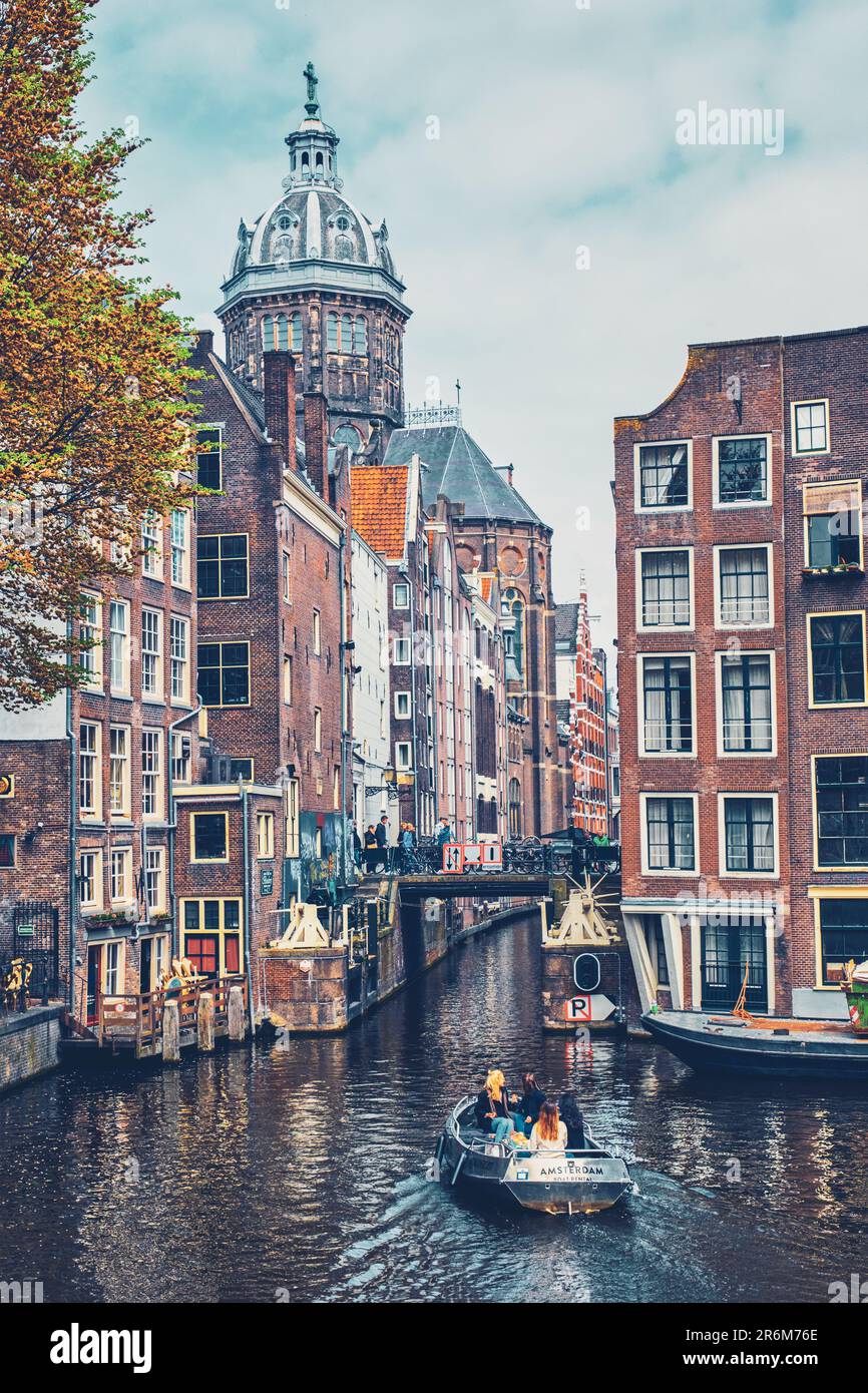 Kanal mit Touristenboot im Amsterdamer Kanal. Amsterdam, Hauptstadt der Niederlande, hat mehr als hundert Kilometer Kanäle Stockfoto