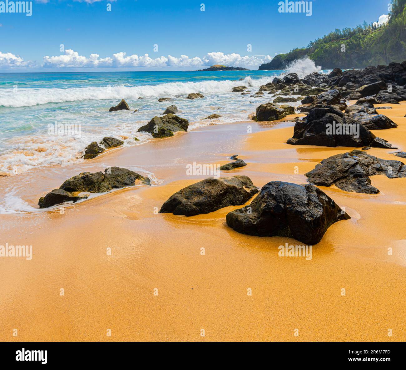 Exponiertes Lava Reef am Sandy Shore mit Kilauea Lighthouse in the Distance, Kauapea Beach, Kauai, Hawaii, USA Stockfoto