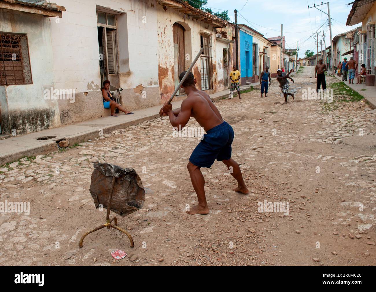 Trinidad, Kuba. Männer spielen Baseball mit einem Stock und Steinen in der unbefestigten Straße. Nur redaktionelle Verwendung. Stockfoto