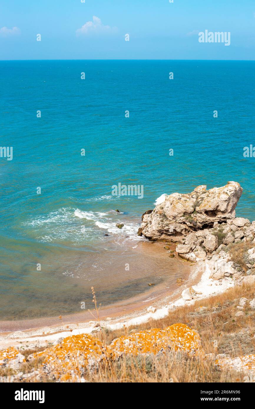 Vertikales Querformat. Meeresküste mit felsigem Ufer und Sandstrand. Blick vom Gipfel des Berges. Asowsche See auf der Krim. Stockfoto