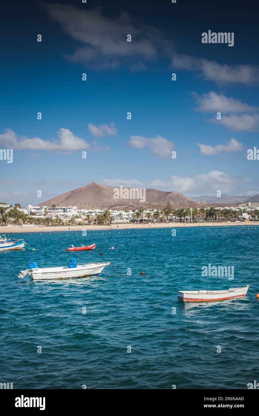 Fischerboote im türkisfarbenen Meer nahe Costa Teguise, Lanzarote, Kanarische Inseln Stockfoto