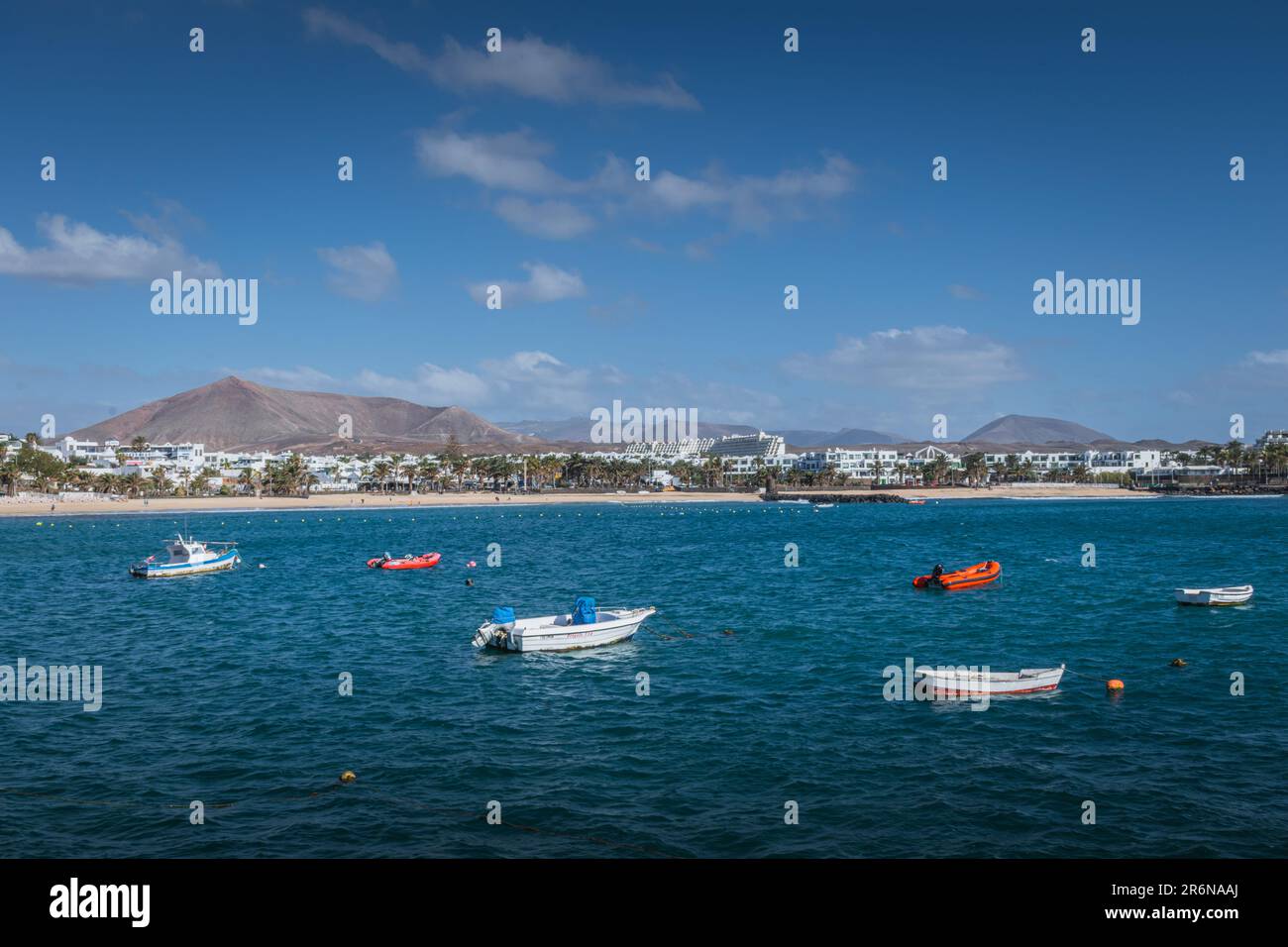 Fischerboote im türkisfarbenen Meer nahe Costa Teguise, Lanzarote, Kanarische Inseln Stockfoto