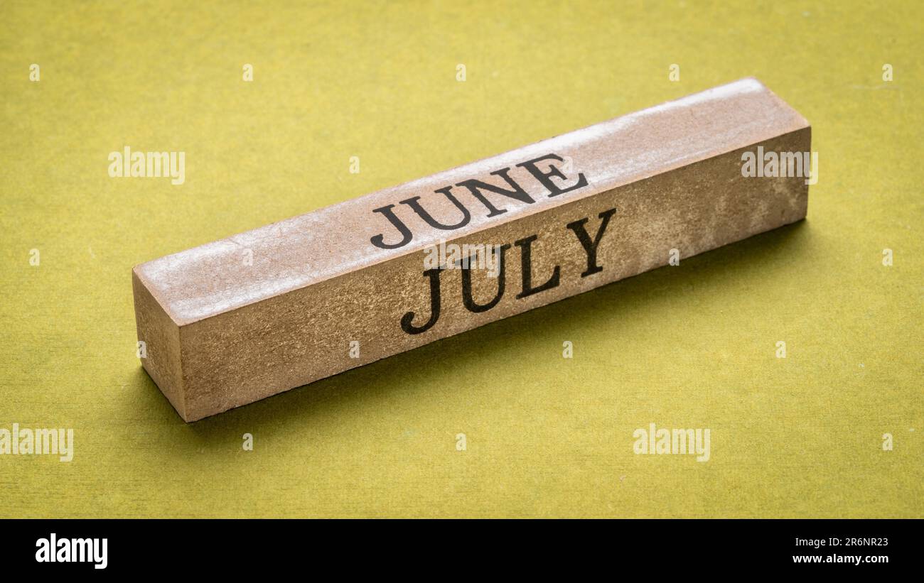 Juni und Juli Text über Grunge Holzblock gegen handgemachtes grünes Lappen Papier, Kalenderkonzept Stockfoto