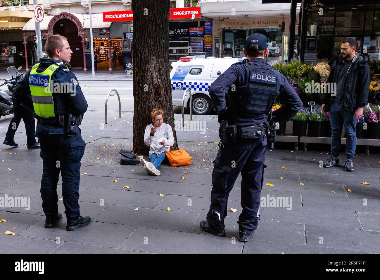 MELBOURNE, AUSTRALIEN - 28. MAI: Polizeibefragung eine Person, die am 28. Mai 2020 in Melbourne, Australien, vor dem Rathaus von Melbourne herumlungert. Als die COVID-19-Krise eskalierte, kündigte Premier Daniel Andrews eine deutliche Erhöhung der Zahl der Polizeibeamten an, die das CBD-Übereinkommen patrouillieren, um die neuen Befugnisse des Notstands durchzusetzen, die am 31. Mai auslaufen. Im Ausnahmezustand können bevollmächtigte Beamte auf Anweisung des Chief Health Officer handeln, um ein ernstes Risiko für die öffentliche Gesundheit zu beseitigen oder zu verringern, indem sie Personen festnehmen, die Bewegungsfreiheit einschränken, den Zutritt zu Räumlichkeiten verhindern oder andere Maßnahmen ergreifen Stockfoto