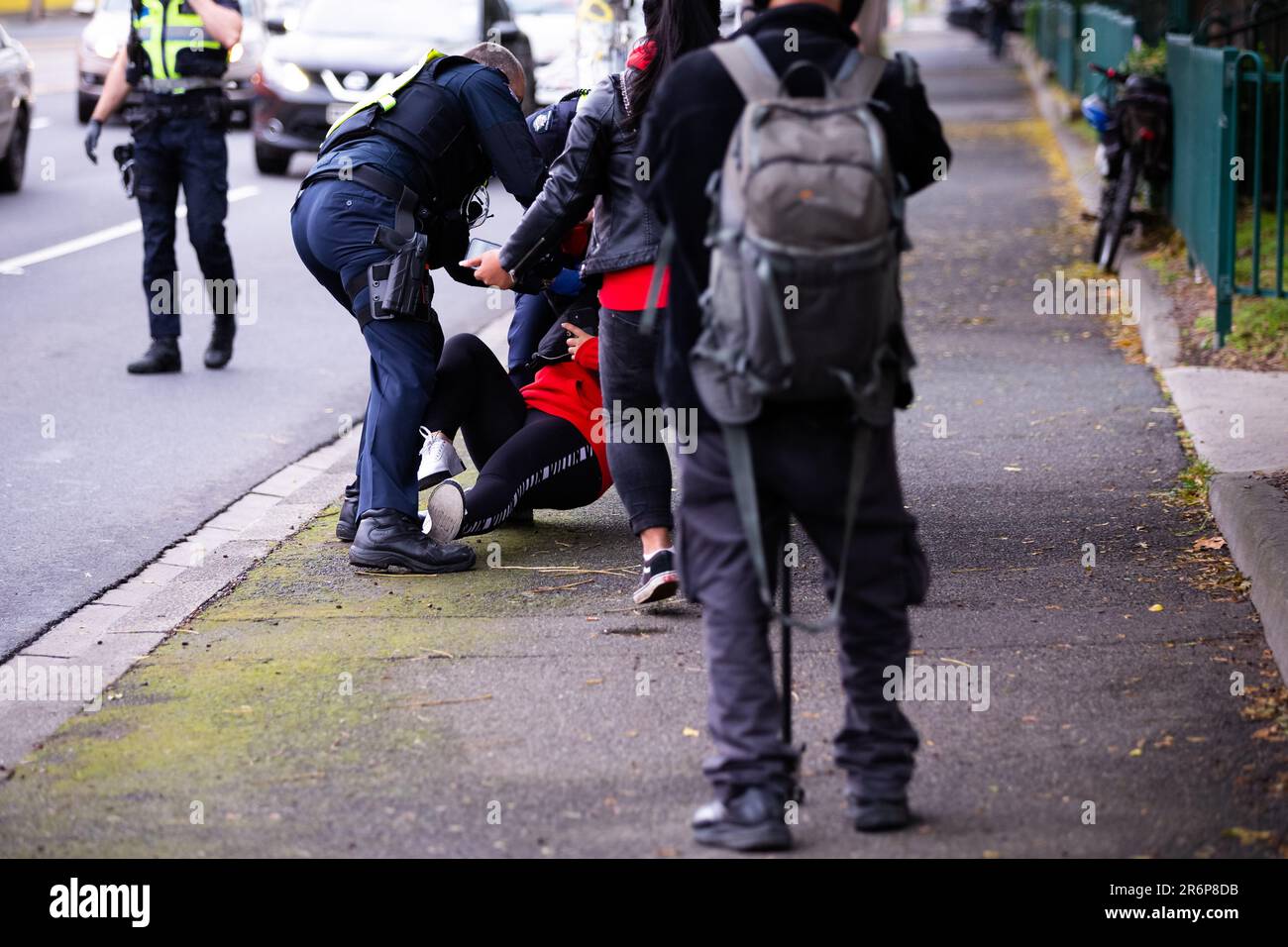 MELBOURNE, AUSTRALIEN - JULI 7: Eine Frau, die auf der Straße steht, um die Bewohner der Rennbahn 120 zu unterstützen, wird gewaltsam zu Boden geschlagen und festgenommen, als die Polizei eine kleine Anzahl von Menschen am dritten vollen Tag der totalen Abriegelung von 9 wohngebäudekommissionen Hochhäuser in die Stadt schmuggelt North Melbourne und Flemington während der COVID-19-Pandemie am 7. Juli 2020 in Melbourne, Australien. Nachdem er 191 COVID-19-Fälle über Nacht aufgenommen hatte, musste Premier Daniel Andrews heute verkünden, dass das gesamte Metropolgebiet Melbourne zusammen mit einem regionalen Zentrum, Mitchell Shire wieder auftauchen wird Stockfoto