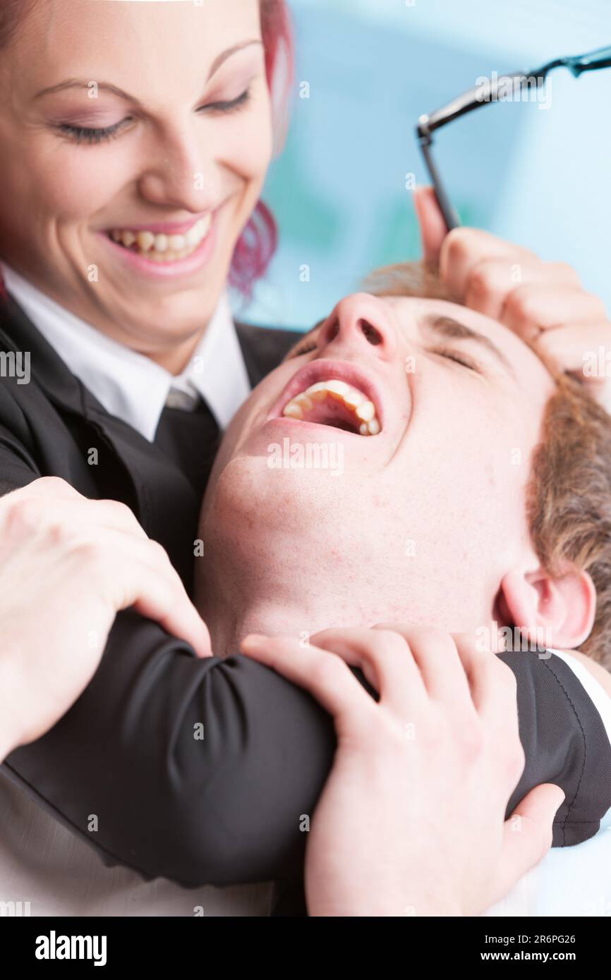 Körperliche Misshandlung bei der Arbeit durch eine Frau gegenüber einem Mann. Zu viel Macht kann zu Unterdrückung führen Stockfoto