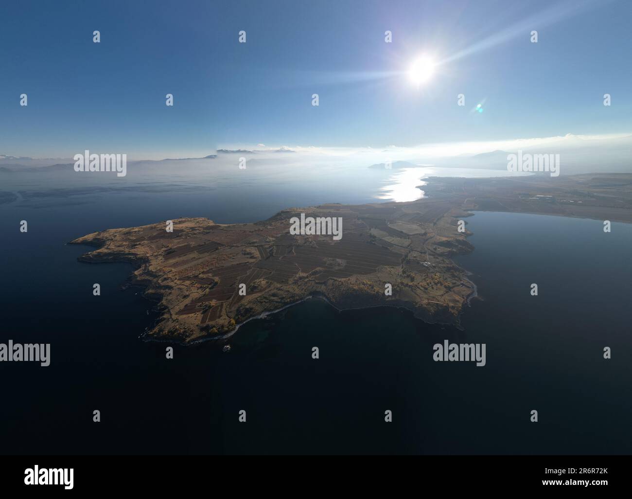 Eine sonnenverwöhnte Insel in einem ruhigen türkisfarbenen Meer mit Blick von oben Stockfoto
