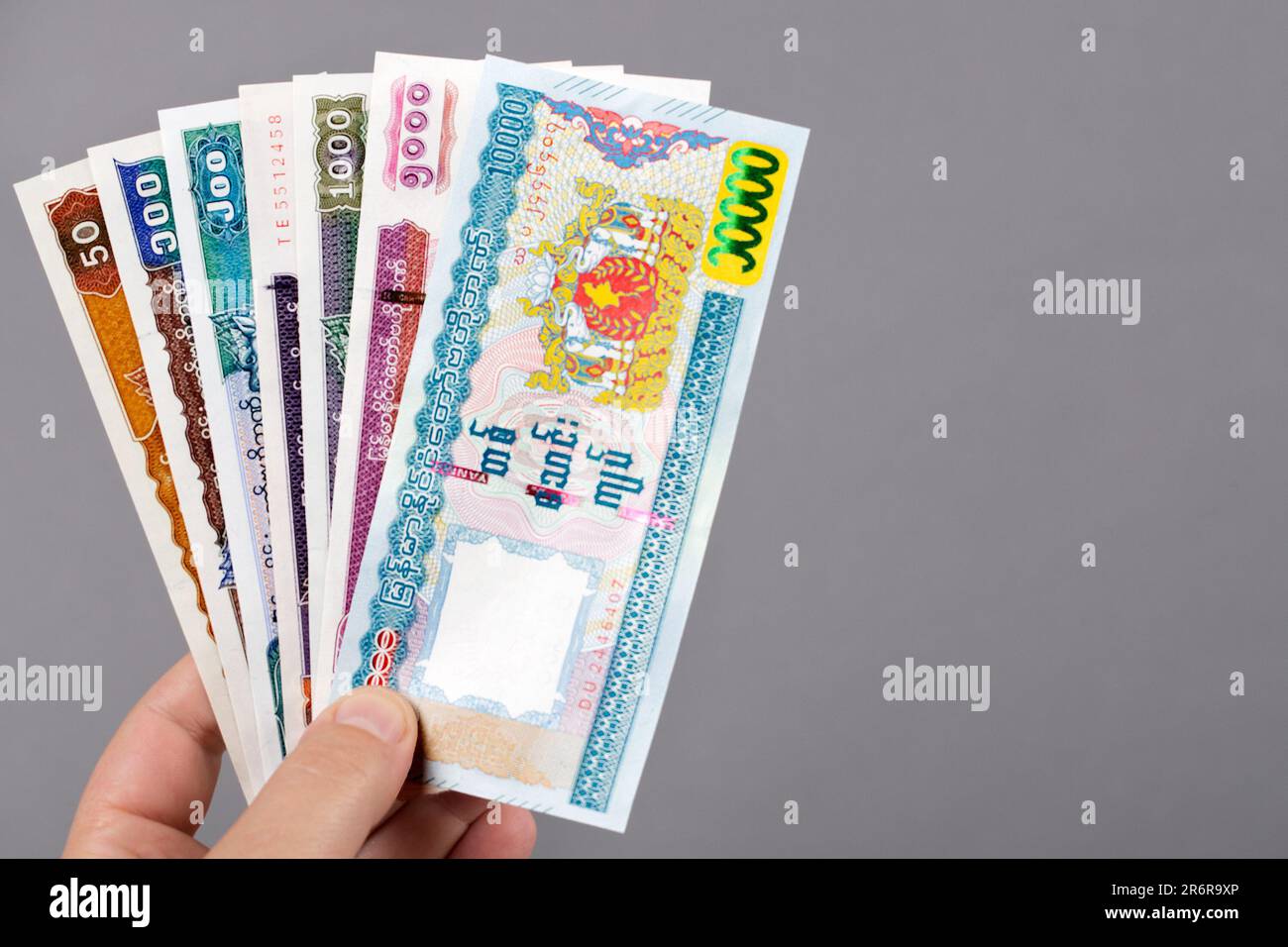 Myanmar Money - Kyat in der Hand auf grauem Hintergrund Stockfoto