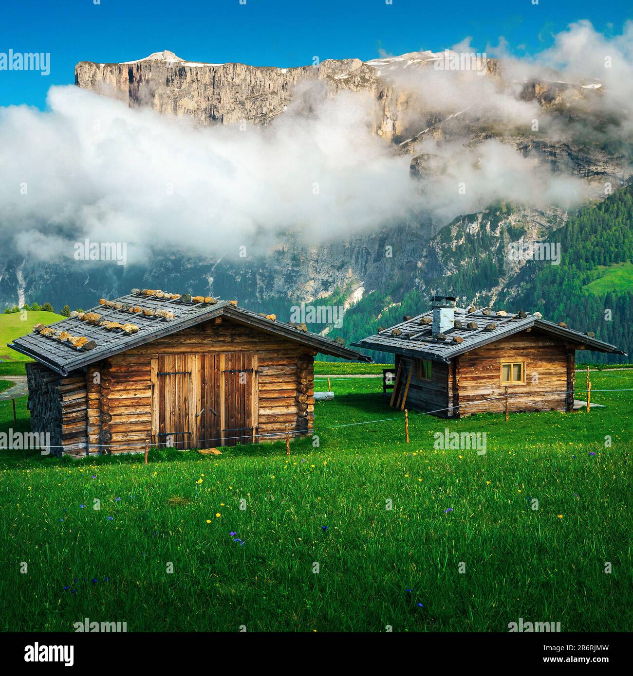 Gemütliche Holzhütten an den grünen Hängen der Dolomiten, Italien, Europa Stockfoto