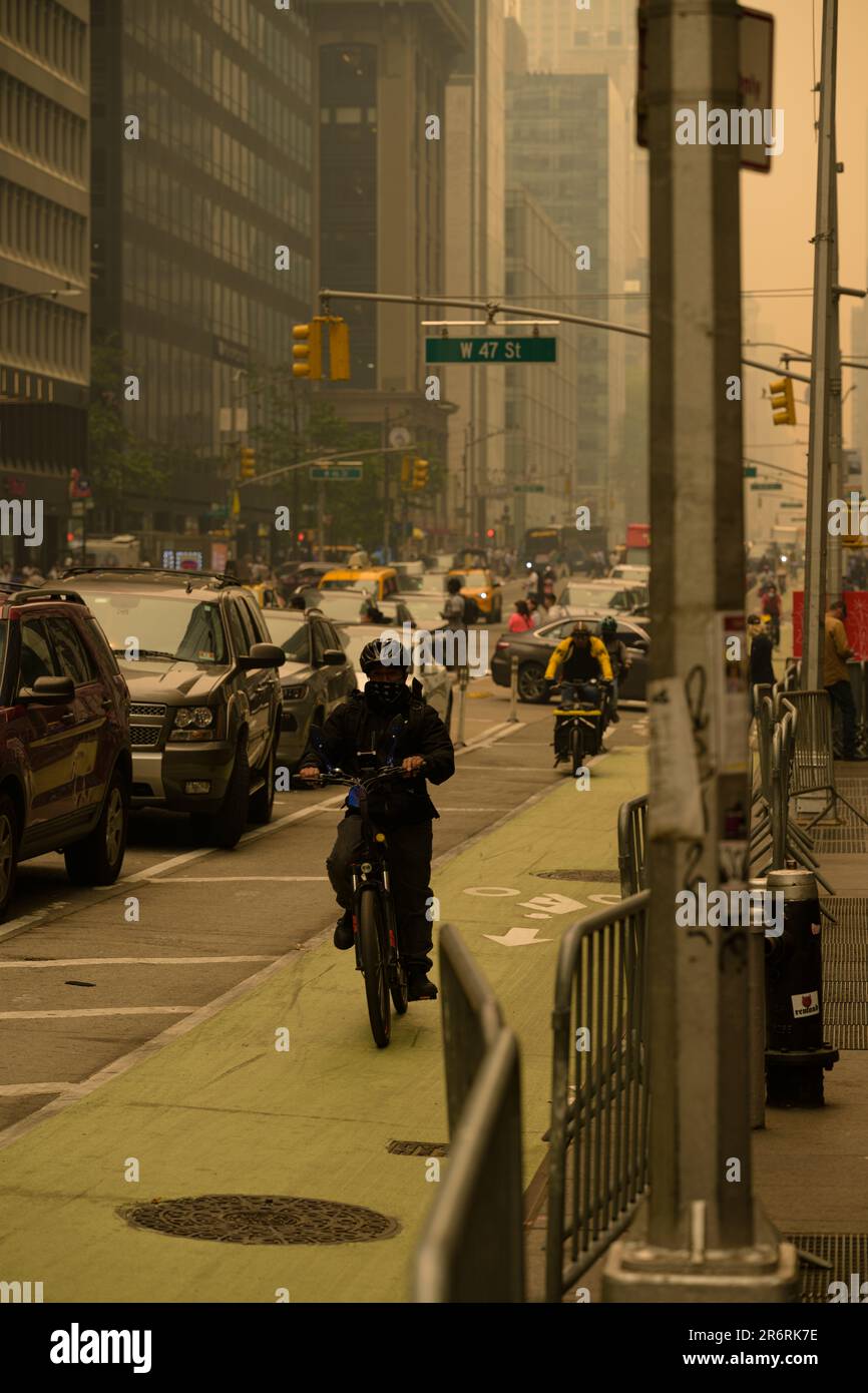 Radfahrer bei gefährlicher Luftqualität in New York City, verursacht durch kanadische Waldbrände. Bild aufgenommen an der 46. und 6. Avenue, 7. Juni 2023. Stockfoto