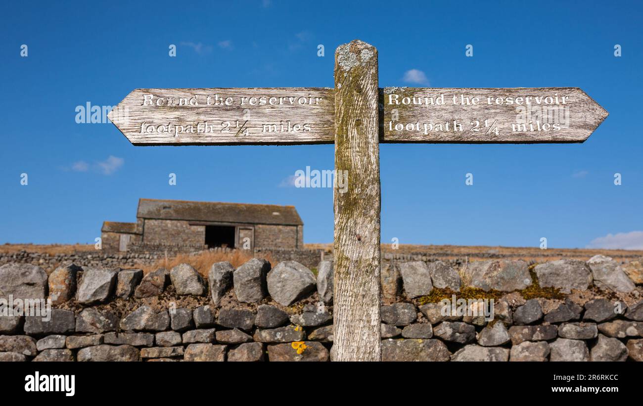 Ein Schild mit den Entfernungen um das Grimwith Reservoir in North Yorkshire, England. Stockfoto