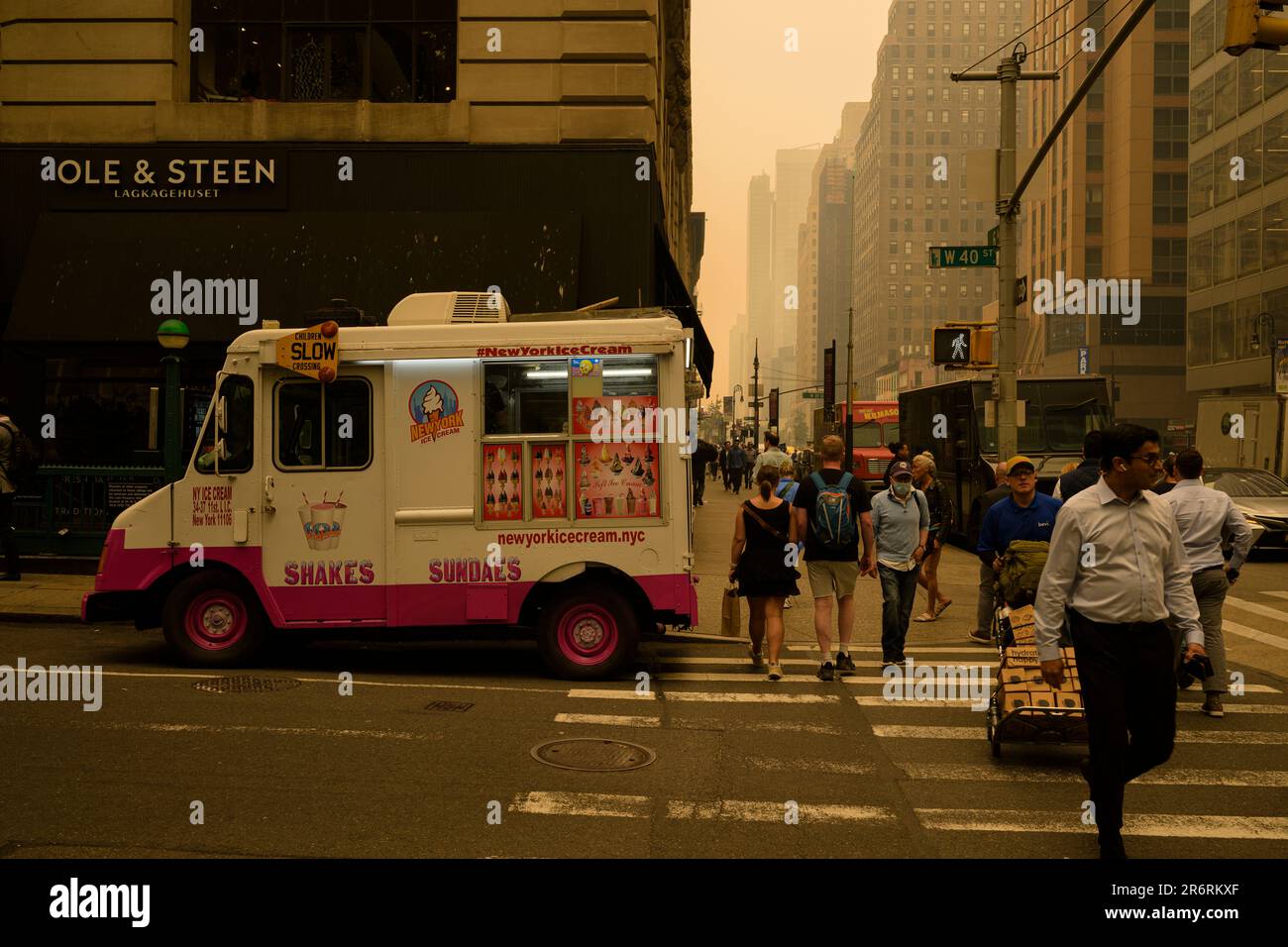 Fußgänger während der gefährlichen Luftqualität in New York City, verursacht durch kanadische Waldbrände. Bild aufgenommen an der 40. und 6. Avenue, 7. Juni 2023. Stockfoto